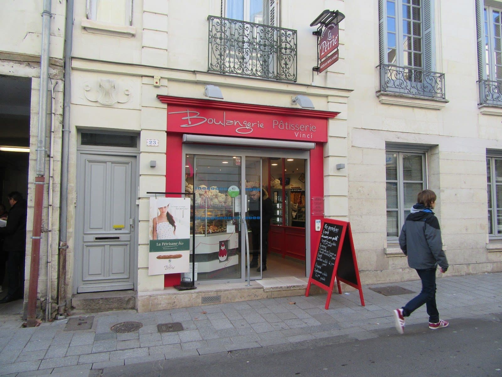 La devanture framboise de la boulangerie vue depuis le trottoir de la rue Bernard Palissy, chevalet d’ardoise devant la porte.